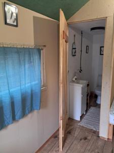 a bathroom with a toilet and a window and a sink at Malowane Wrota Camp - Gniazdko in Łazy