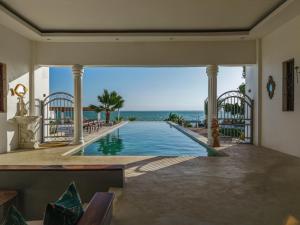 an indoor swimming pool with a view of the ocean at beacfront villa claudius ,michamvi in Michamvi
