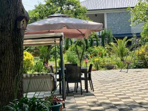 an umbrella sitting on a table in a garden at Casa Bianca Kobuleti in Kobuleti