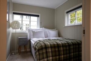 a bedroom with a bed with white pillows and a window at Aurland Guesthouse in Aurland