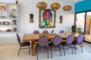 a dining room with a table with purple chairs at beacfront villa claudius ,michamvi in Michamvi