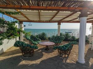 a patio with a table and chairs and the ocean at beacfront villa claudius ,michamvi in Michamvi +9 photos