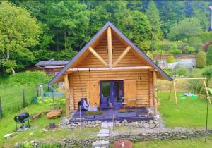 a log cabin with a porch and a grill at Chatka pod lasem Szczyrk Domek z jacuzzi in Szczyrk