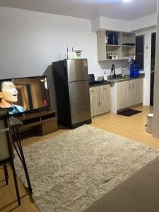 a living room with a tv and a kitchen at Lis Urban Residence in Manila