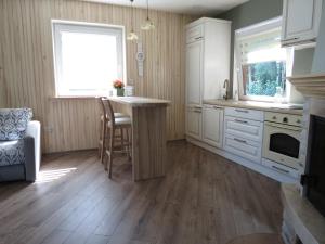 a kitchen with white cabinets and a table and a window at Namelio-mini vilos nuoma in Palanga