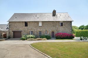 a large brick house with a garage and flowers at L'aoûtienne - 300m de la plage in Saint-Coulomb