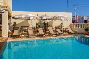 a swimming pool with lounge chairs and umbrellas next to a pool at Ciello Hotel Bodrum Adults Only 14 in Bodrum City