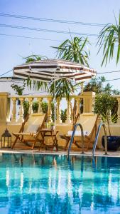 a pool with two chairs and an umbrella at Ciello Hotel Bodrum Adults Only 14 in Bodrum City