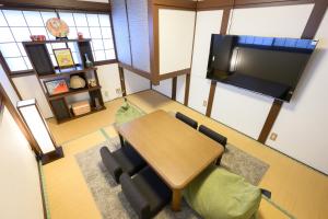 a room with a table and chairs and a flat screen tv at soleggiato suminoe in Osaka