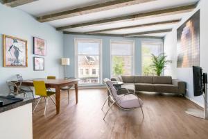 a living room with a couch and a table and chairs at Five Churches View apartments in Haarlem