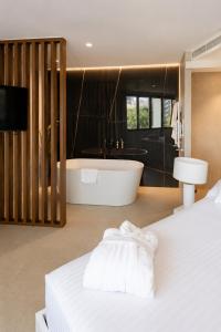 a bedroom with a bath tub and a white bed at Hotel Condestable Iranzo in Jaén +86 photos