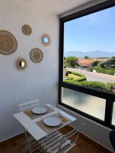 a dining room with a table and a large window at Apartment - Beach - AC - Private parking in Saint-Cyprien-Plage
