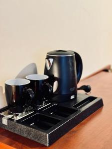 a black coffee pot on a tray on a table at Willa Róża Karkonoszy in Jelenia Góra