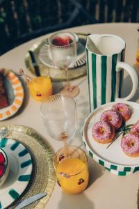 a table with plates of donuts and glasses of orange juice at Knus I Tiny house op de Veluwe in Epe