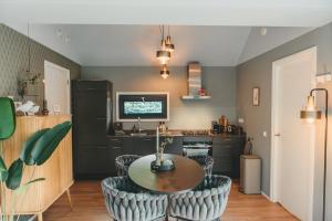 a kitchen with a table and chairs in a room at Knus I Tiny house op de Veluwe in Epe