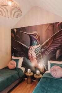 a bedroom with a bird mural on the wall at Knus I Tiny house op de Veluwe in Epe