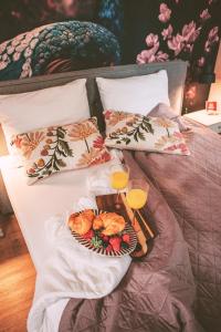 a bed with a tray of food and two glasses of orange juice at Knus I Tiny house op de Veluwe in Epe +50 photos