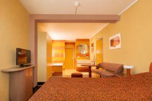 a hotel room with a bed and a bathroom at Hotel Domburg4you in Domburg