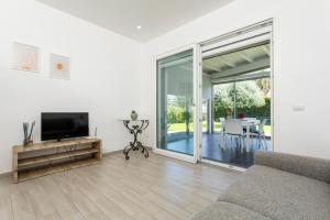 a living room with a couch and a flat screen tv at Tropical House in San Leonardello