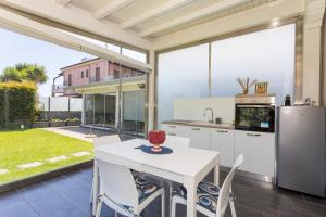a kitchen with white appliances and a table with chairs at Tropical House in San Leonardello