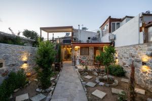 a house with a courtyard with a stone wall at Stefanis Guest House II in Krásion