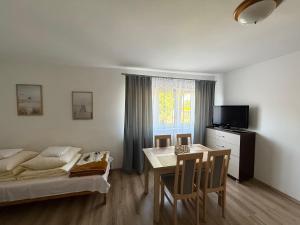 a room with a table and a bed and a dining room at Pokoje i apartamenty Pod Dębem in Rowy