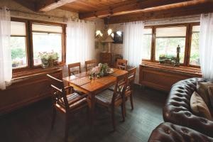 a dining room with a table and chairs and windows at Chata Ostrov - Eiland v srdci Českého Švýcarska in Tisá