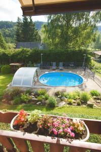 a swimming pool in a garden with flowers at Chata Ostrov - Eiland v srdci Českého Švýcarska in Tisá