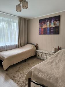 a bedroom with two beds and a window at Family Apartament in Narva-Jõesuu