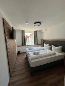a bedroom with two beds and a large window at Hotel Rad in Leutkirch im Allgäu
