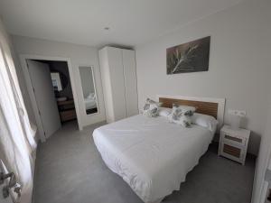 a bedroom with a white bed with two pillows at Jardín del Jiloca in Calamocha
