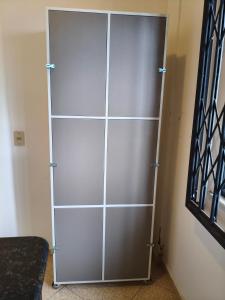 a metal closet with silver doors in a room at Hostel Dunas & Mar - Hostel e Suítes - Cabo Frio in Cabo Frio