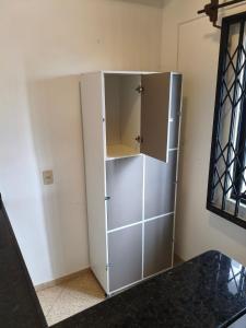 a large white cabinet in a corner of a room at Hostel Dunas & Mar - Hostel e Suítes - Cabo Frio in Cabo Frio