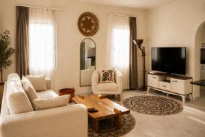 a living room with a couch and a tv at Ciello Hotel Bodrum Adults Only 14 in Bodrum City