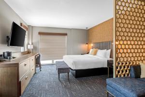 a hotel room with a bed and a television at Beacon Suites Hotel in Somerville