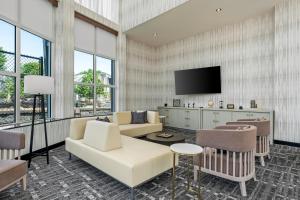 a living room with a couch and a tv at Beacon Suites Hotel in Somerville