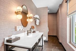 a bathroom with a sink and a mirror at Beacon Suites Hotel in Somerville +23 photos
