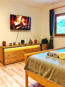 a bedroom with a bed with a fireplace under a tv at Das Försterhaus 41 in Aschau