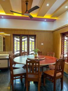 a dining room with a table and some chairs at Coffeehut Pool Villa in Pinangode