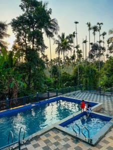 two people are standing in a swimming pool at Coffeehut Pool Villa in Pinangode