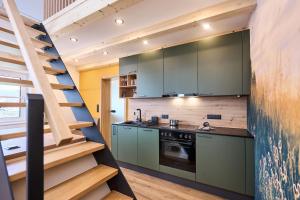 a kitchen with green cabinets and a staircase at Wiegehaus Retz in Retz