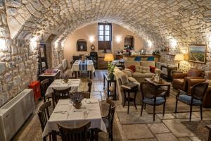 a restaurant with tables and chairs in a stone building at Archontiko Leontari in Leondari