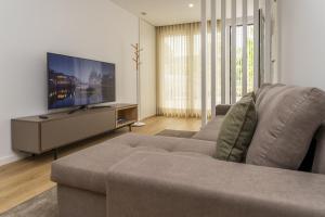 a living room with a couch and a flat screen tv at Refugio Moderno as Portas do Geres in Ponte da Barca
