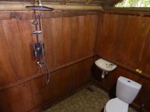 a small bathroom with a toilet and a sink at Shibui Garden Bungalows and Restaurant in Tanjung +28 photos