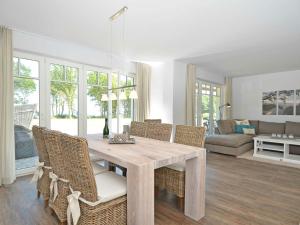 a dining room with a wooden table and chairs at Reethus am Strand - Haushälfte 1 mit Kamin, Sauna in Lobbe