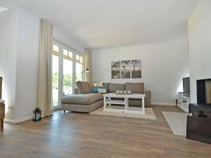 a living room with a couch and a table at Reethus am Strand - Haushälfte 1 mit Kamin, Sauna in Lobbe