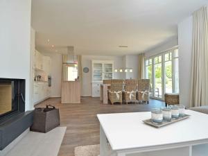 a living room with a kitchen and a living room with a fireplace at Reethus am Strand - Haushälfte 1 mit Kamin, Sauna in Lobbe