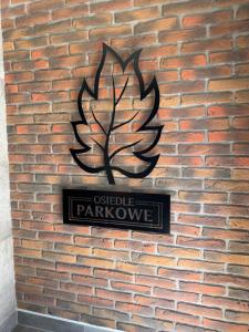a sign on a brick wall with a tree on it at Apartament Milicz in Milicz