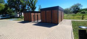 two wooden structures sitting on a brick patio at Apartament Milicz in Milicz