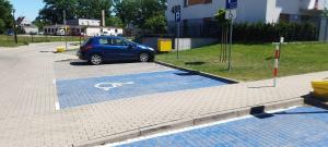 a blue car parked in a handicapped parking lot at Apartament Milicz in Milicz